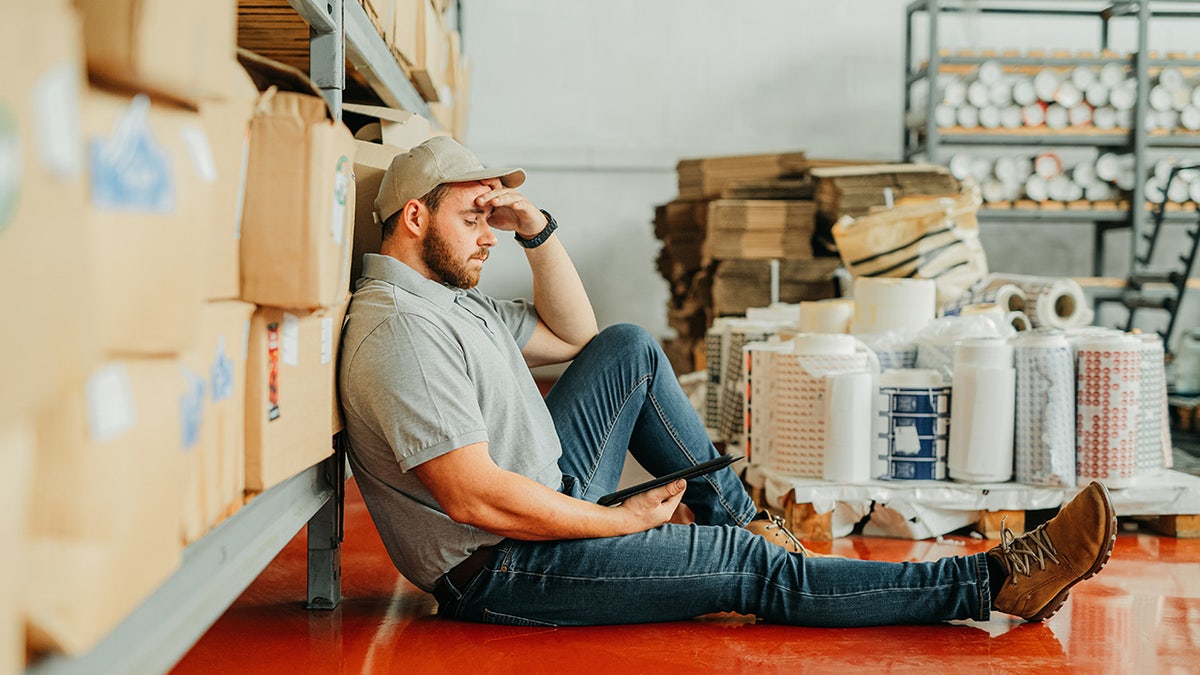 Warehouse installation worker is on the tired floor