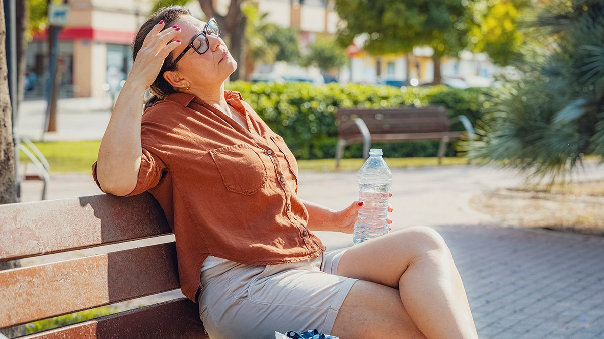 The woman sits on the summer heat